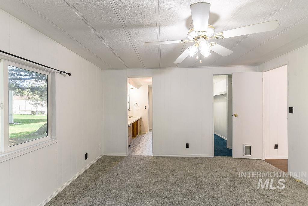 609 North Almon Street, Unit 2011 Moscow, ID 83843 - Photo 32 of 45 Unfurnished bedroom with carpet floors, a walk in closet, a ceiling fan, and a textured ceiling
