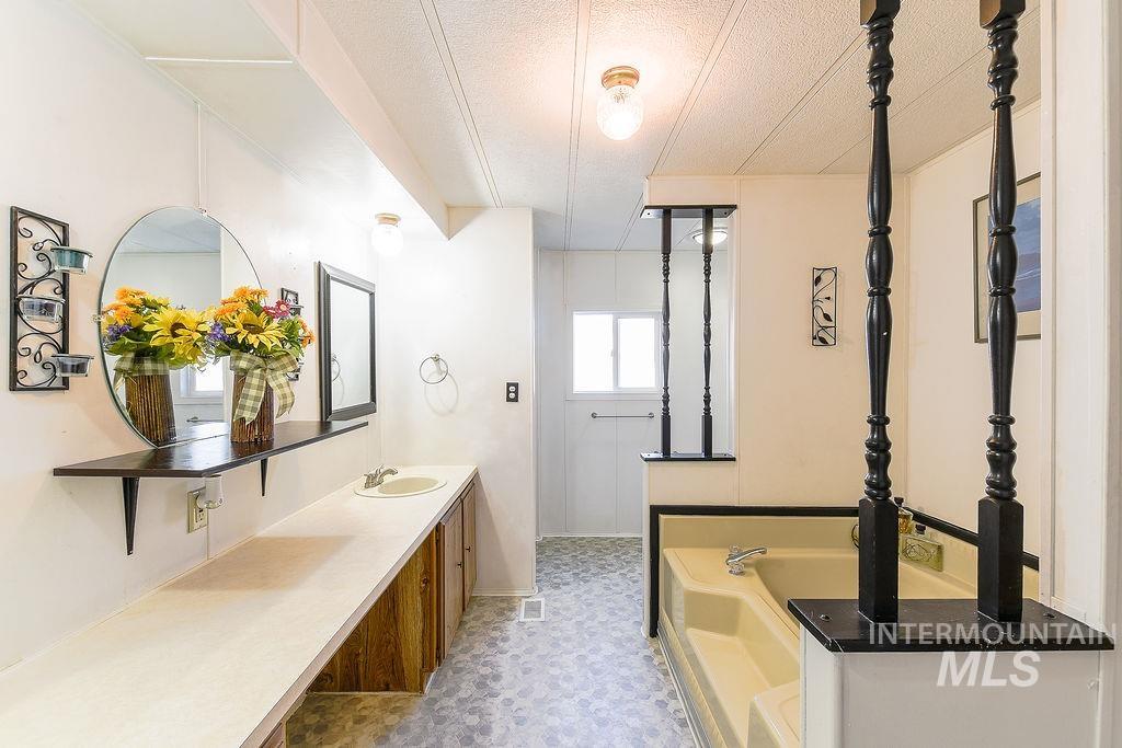 609 North Almon Street, Unit 2011 Moscow, ID 83843 - Photo 36 of 45 Full bathroom with vanity, a bath, a textured ceiling, and light flooring