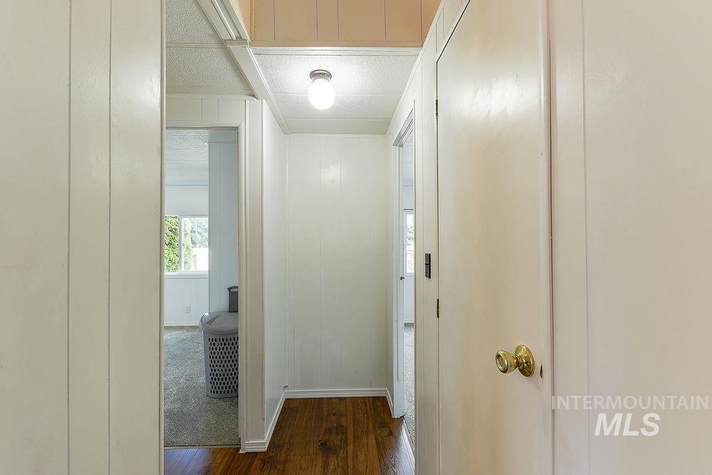 609 North Almon Street, Unit 2011 Moscow, ID 83843 - Photo 10 of 45 Hallway with dark wood-style flooring, wood walls, and a textured ceiling