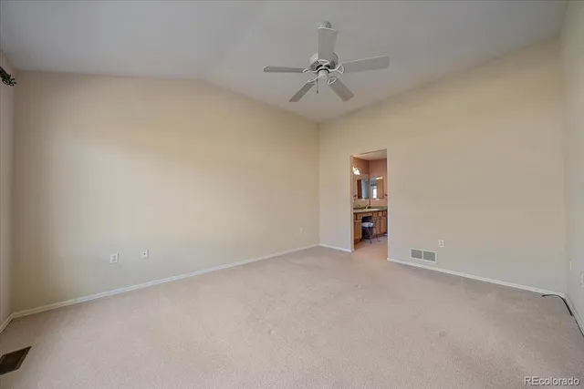 a view of an empty room and chandelier fan