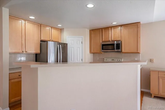 a kitchen with stainless steel appliances a refrigerator sink and microwave