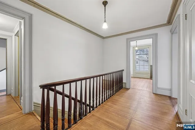 a view of a hallway with wooden floor and windows