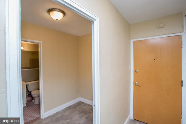 a view of a hallway with a room that has a glass door and painted walls