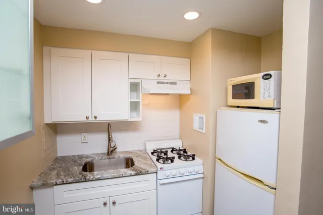 a kitchen with granite countertop cabinets stainless steel appliances and a sink