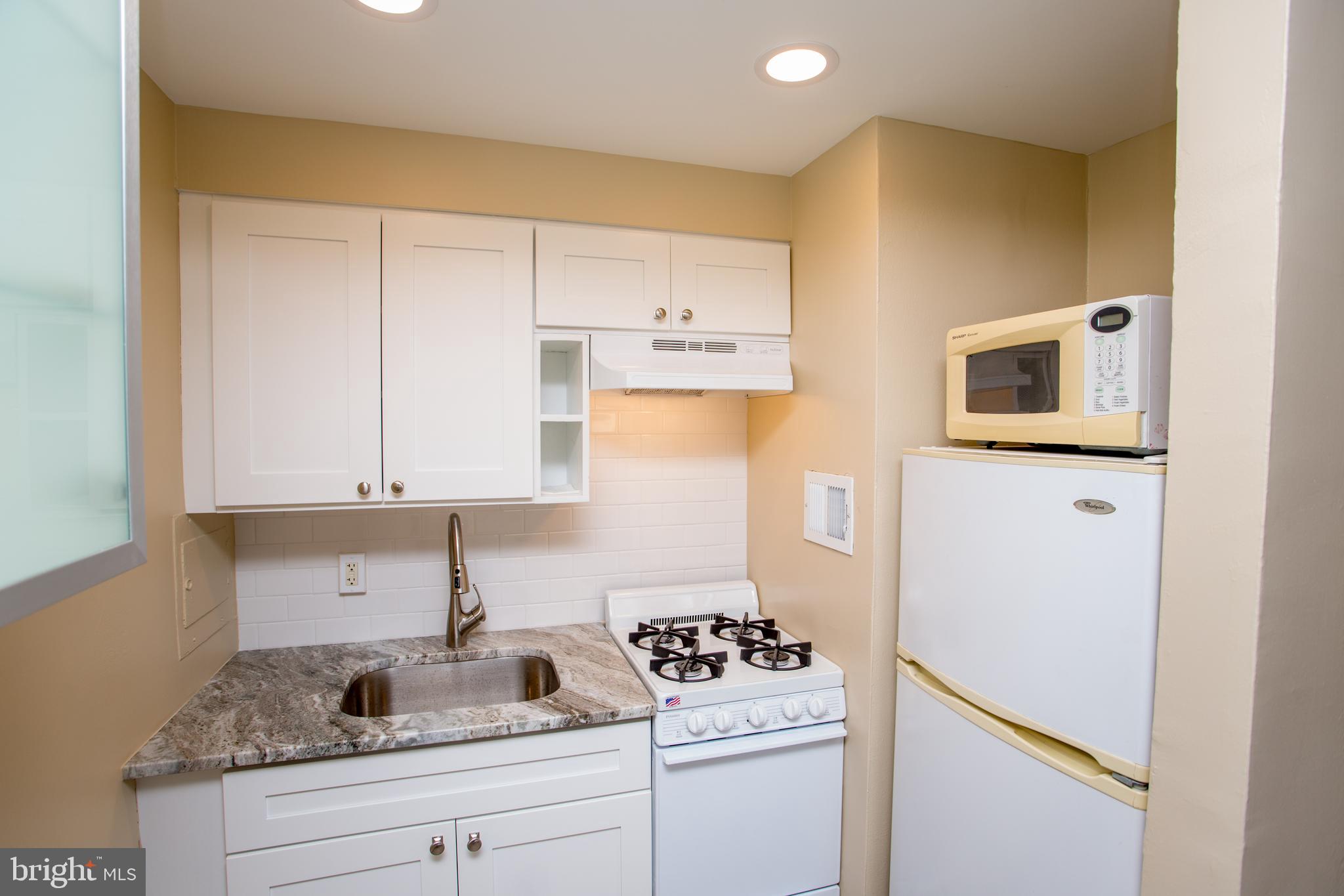2101-17 Chestnut Street, Unit 1809 Philadelphia, PA 19103 - Photo 19 of 38 a kitchen with granite countertop cabinets stainless steel appliances and a sink