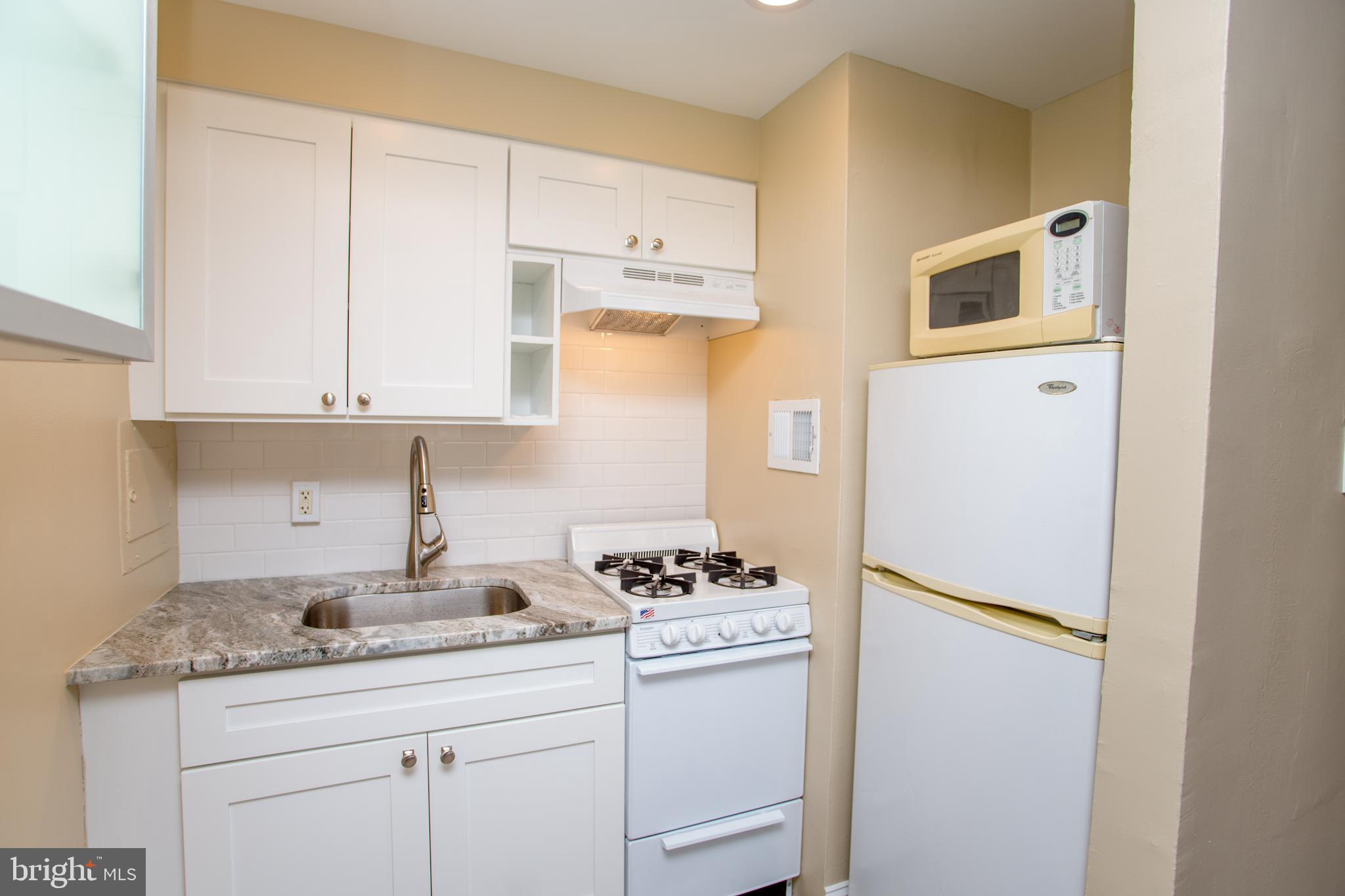 2101-17 Chestnut Street, Unit 1809 Philadelphia, PA 19103 - Photo 21 of 38 a kitchen with appliances a sink and cabinets