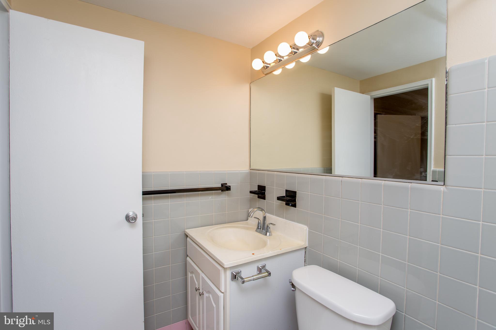2101-17 Chestnut Street, Unit 1809 Philadelphia, PA 19103 - Photo 23 of 38 a bathroom with a sink a toilet and mirror