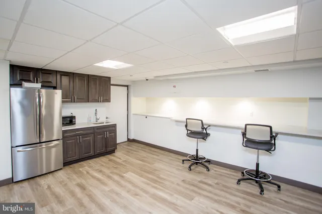 a kitchen with stainless steel appliances refrigerator wooden floor and cabinets