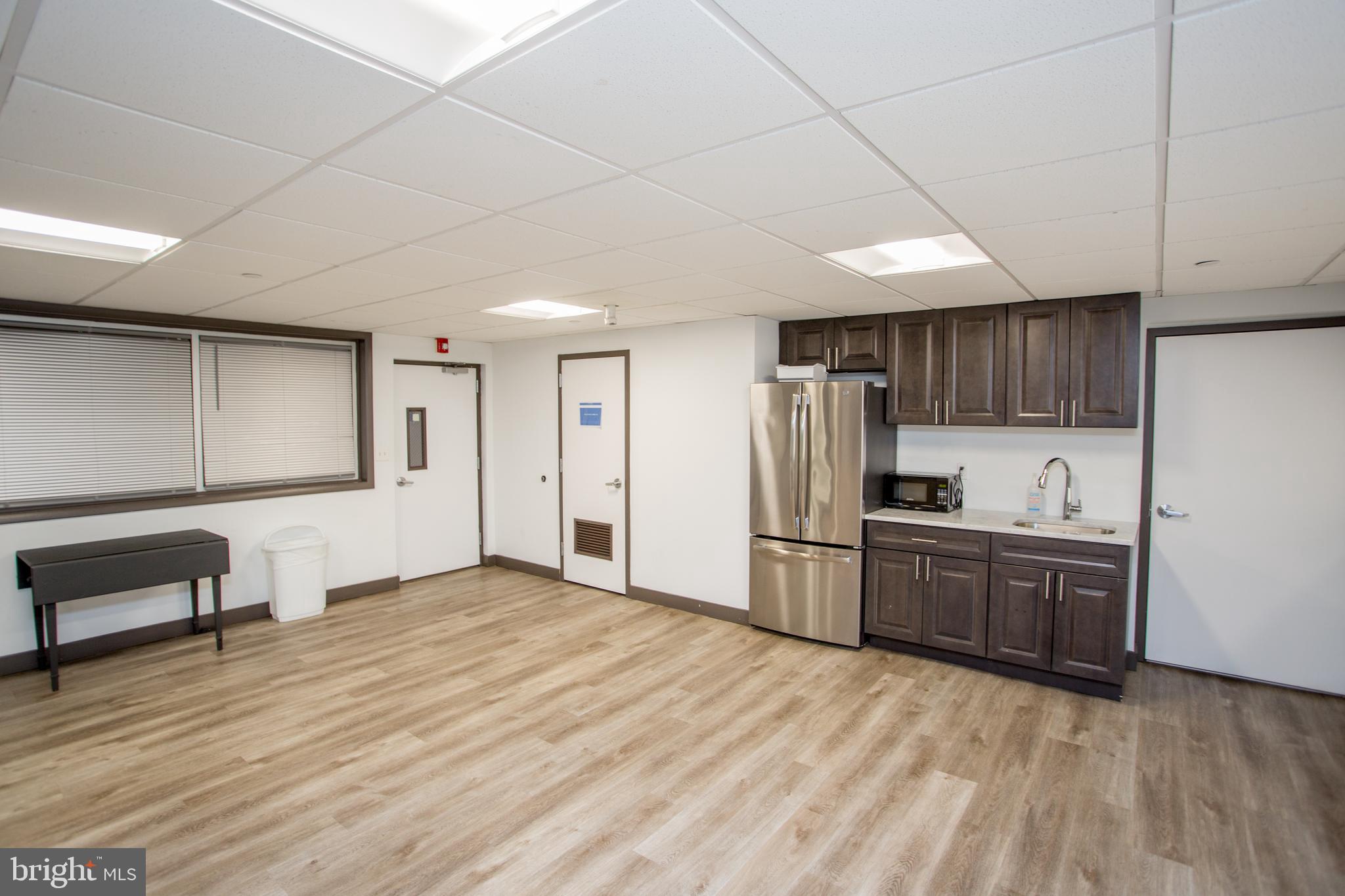 2101-17 Chestnut Street, Unit 1809 Philadelphia, PA 19103 - Photo 32 of 38 a kitchen with stainless steel appliances kitchen island granite countertop a refrigerator oven a sink dishwasher and white cabinets with wooden floor