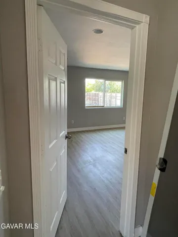 a view of a room with wooden floor and white walls