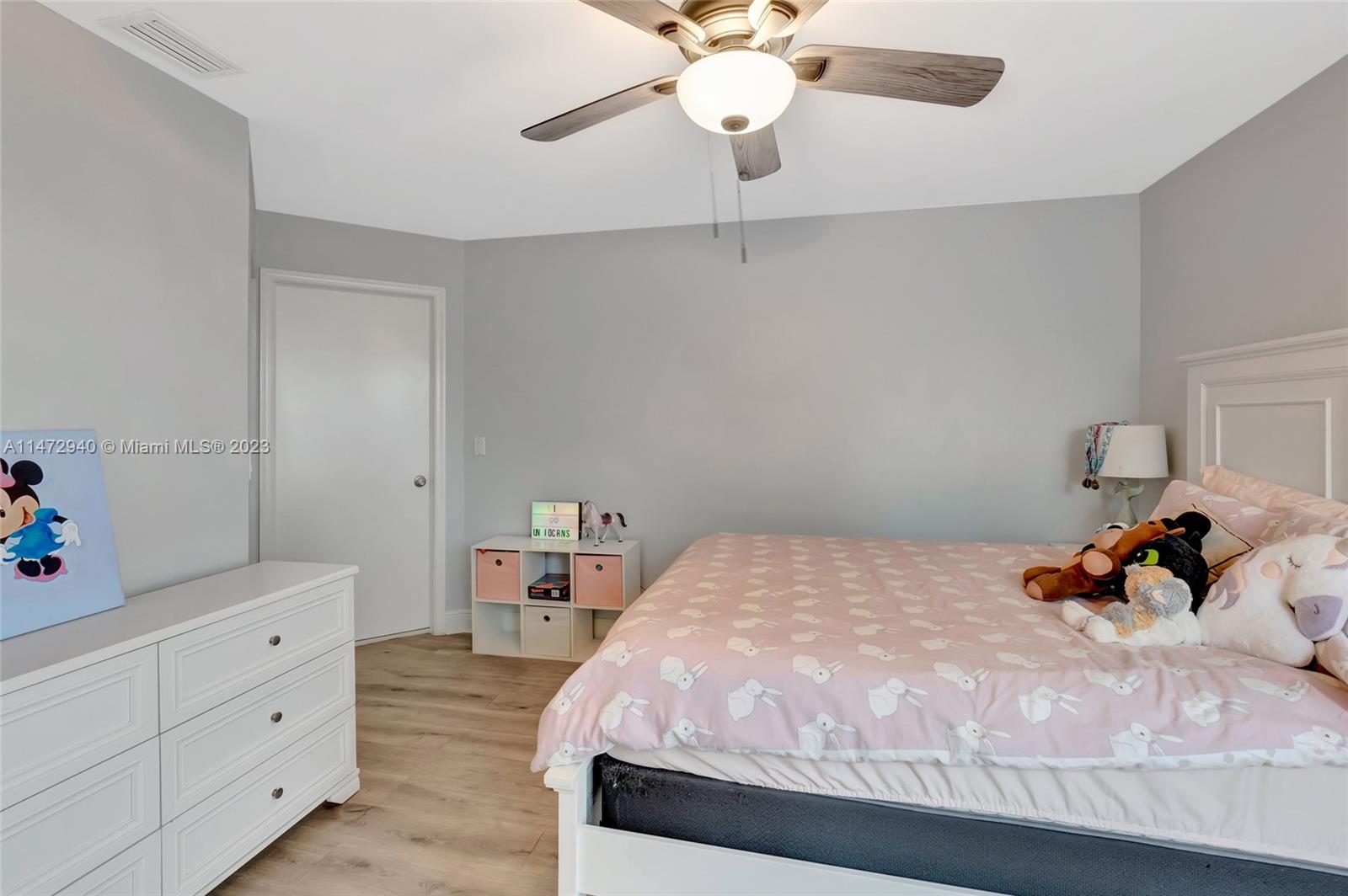 6636 Northwest 25th Avenue Boca Raton, FL 33496 - Photo 36 of 96 a bedroom with a bed and a chandelier