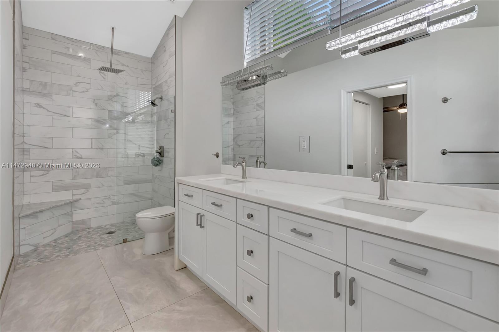 6636 Northwest 25th Avenue Boca Raton, FL 33496 - Photo 39 of 96 a bathroom with a double vanity sink a toilet and a shower