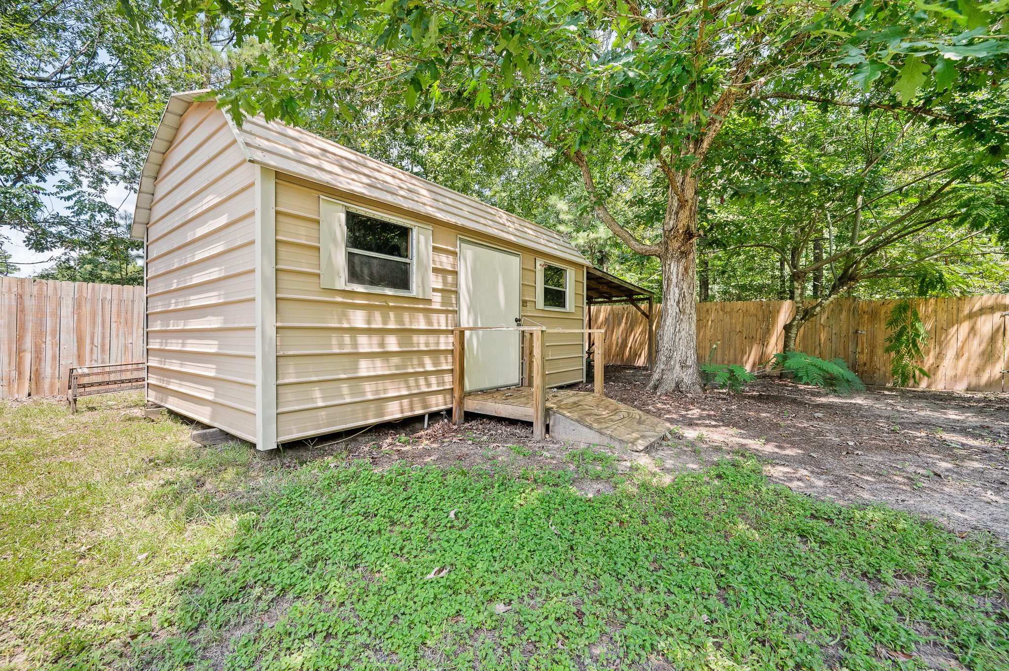 61 Hicks Loop West Cleveland, TX 77328 - Photo 31 of 38 Charming backyard shed nestled among mature trees, offering a serene and private retreat.