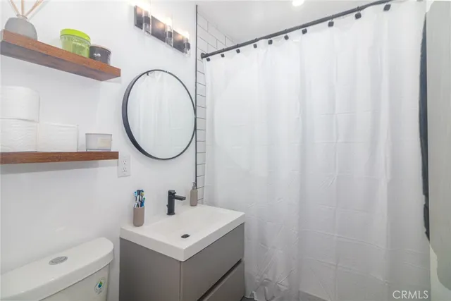 a bathroom with a sink a toilet and a mirror