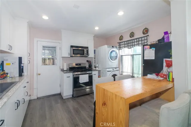 a kitchen with granite countertop a sink appliances cabinets and counter space