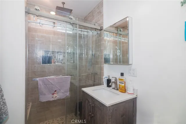 a bathroom with a shower sink and mirror