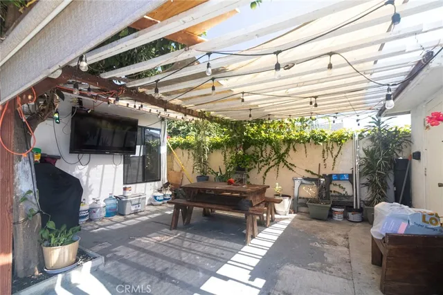 a living room with patio furniture and a flat screen tv