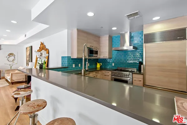 a kitchen with stainless steel appliances granite countertop a sink and a refrigerator