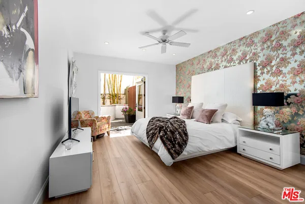 a spacious bedroom with a bed and a flat screen tv