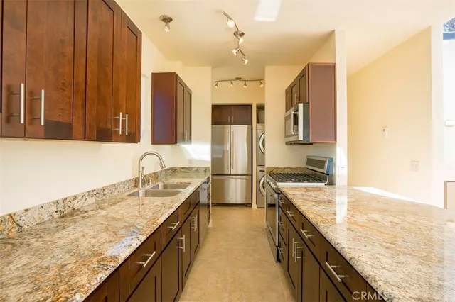 a kitchen with granite countertop a sink stove and refrigerator