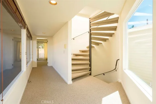 a view of a hallway with staircase and white walls