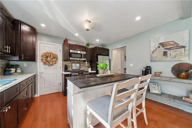a kitchen with granite countertop a table chairs stove and cabinets