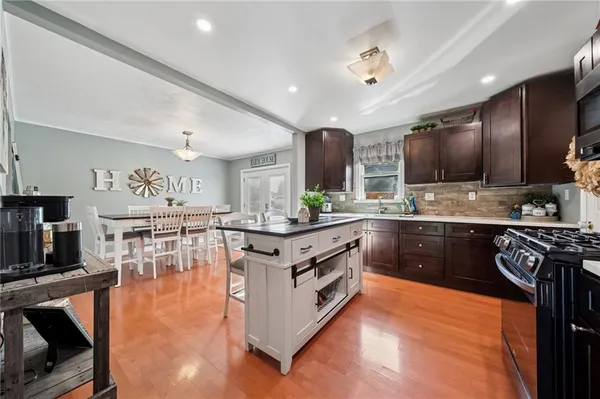 a kitchen with stainless steel appliances granite countertop a stove cabinets and wooden floor