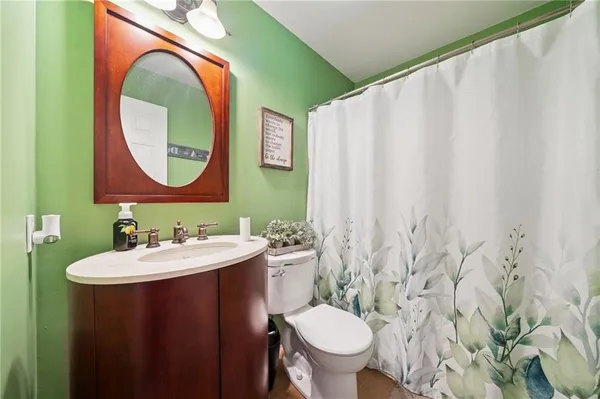 a bathroom with a toilet sink and mirror