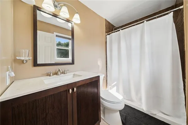 a bathroom with a sink a toilet and a mirror