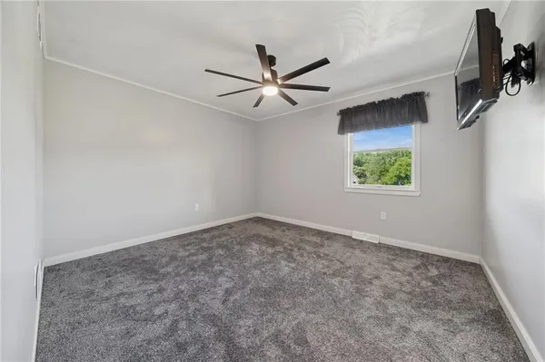 an empty room with a window and a fan