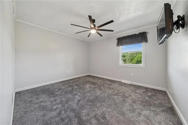 an empty room with a window and a fan