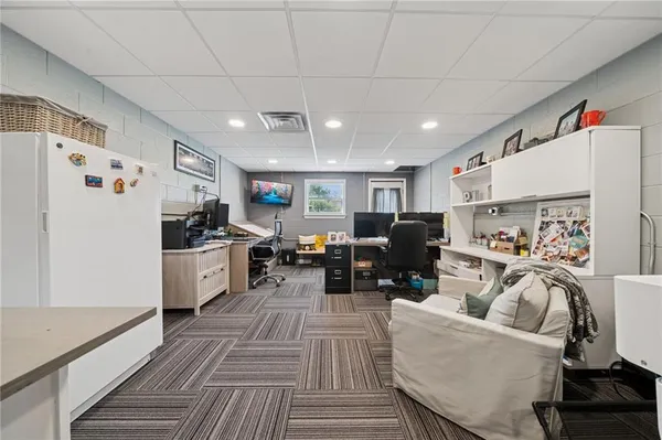 a living room with furniture and a refrigerator