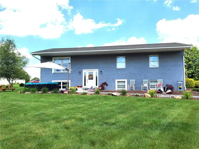 a front view of a house with a garden and trees
