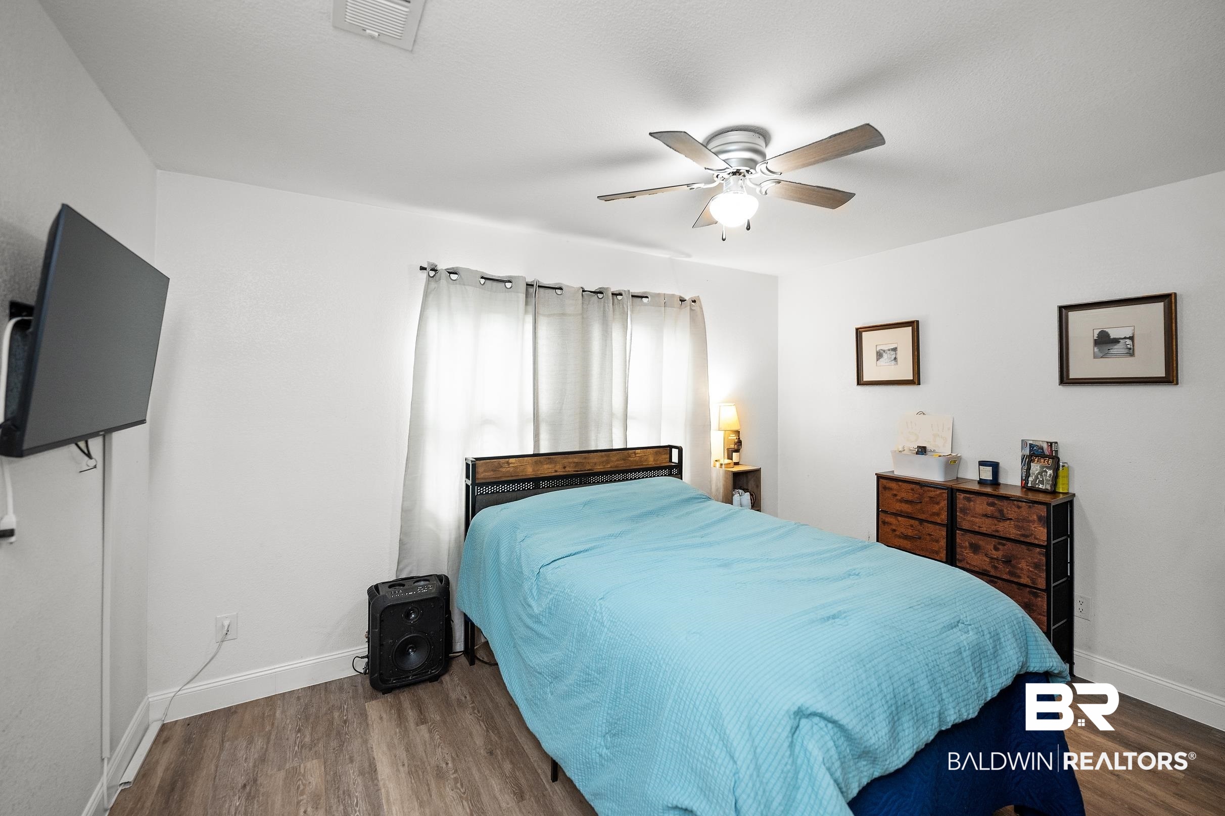 33129 Antietam Road Lillian, AL 36549 - Photo 14 of 31 Bright room featuring wood-finish flooring, white walls, and a ceiling fan with integrated lighting