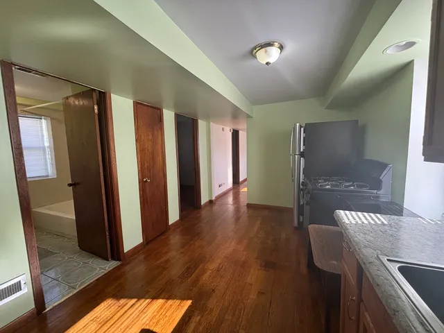 a view of a hallway with furniture and wooden floor