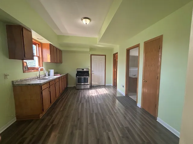 a kitchen with sink cabinets and wooden floor