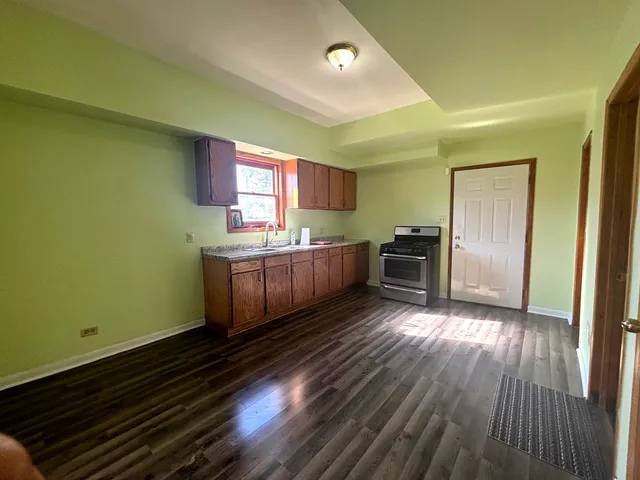 a kitchen with cabinets and wooden floor