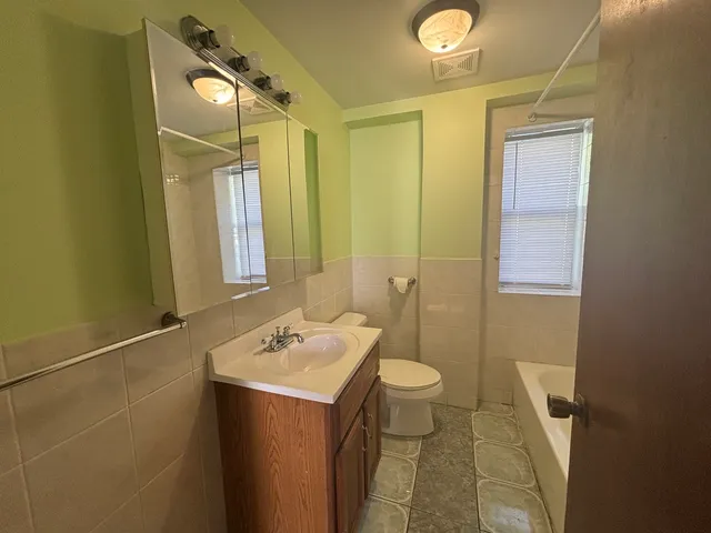 a bathroom with a sink a toilet a mirror and shower