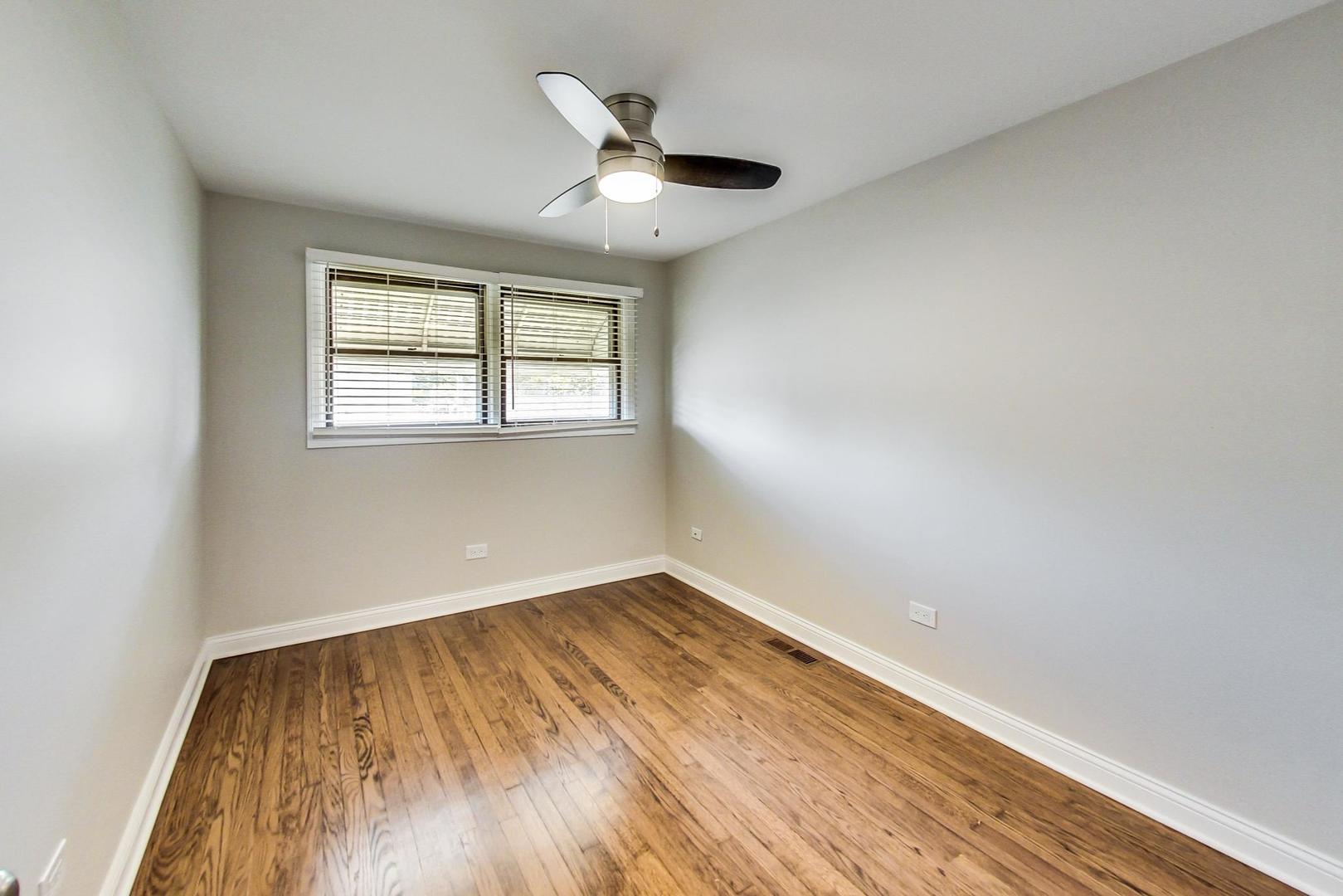 3702 South Normal Avenue Chicago, IL 60609 - Photo 17 of 36 an empty room with wooden floor and windows
