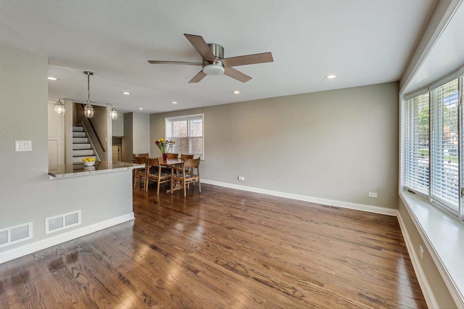 3702 South Normal Avenue Chicago, IL 60609 - Photo 3 of 36 a view of a room with wooden floor a ceiling fan and windows