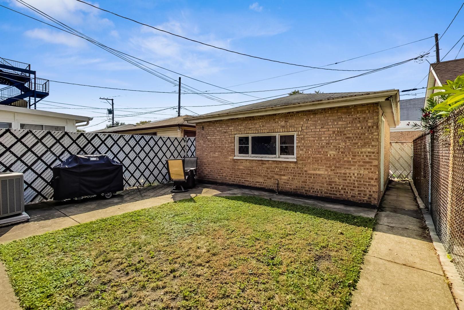 3702 South Normal Avenue Chicago, IL 60609 - Photo 32 of 36 a backyard of a house with barbeque oven table and chairs