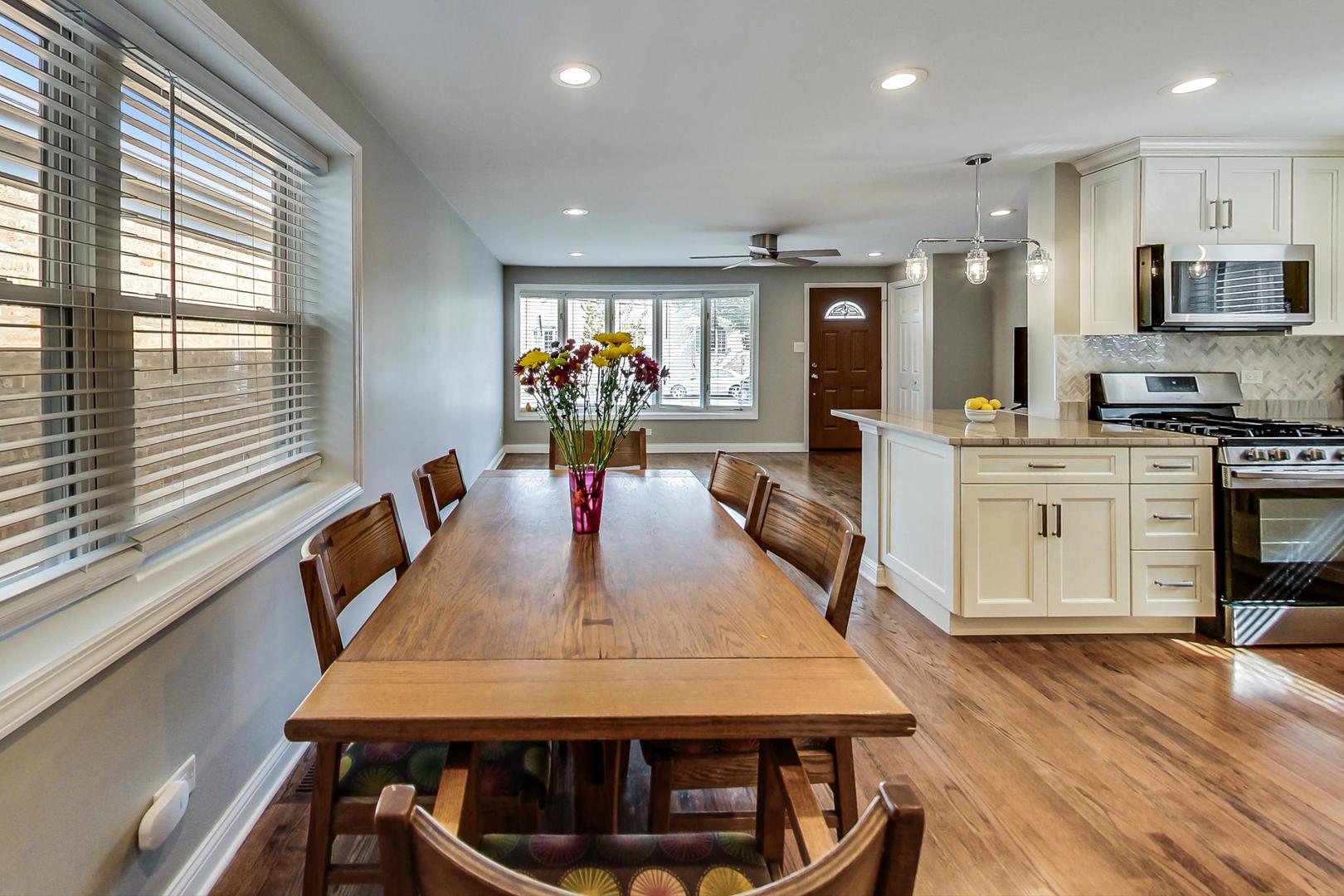 3702 South Normal Avenue Chicago, IL 60609 - Photo 7 of 36 a kitchen with stainless steel appliances granite countertop a stove top oven a sink dishwasher a dining table and chairs with wooden floor