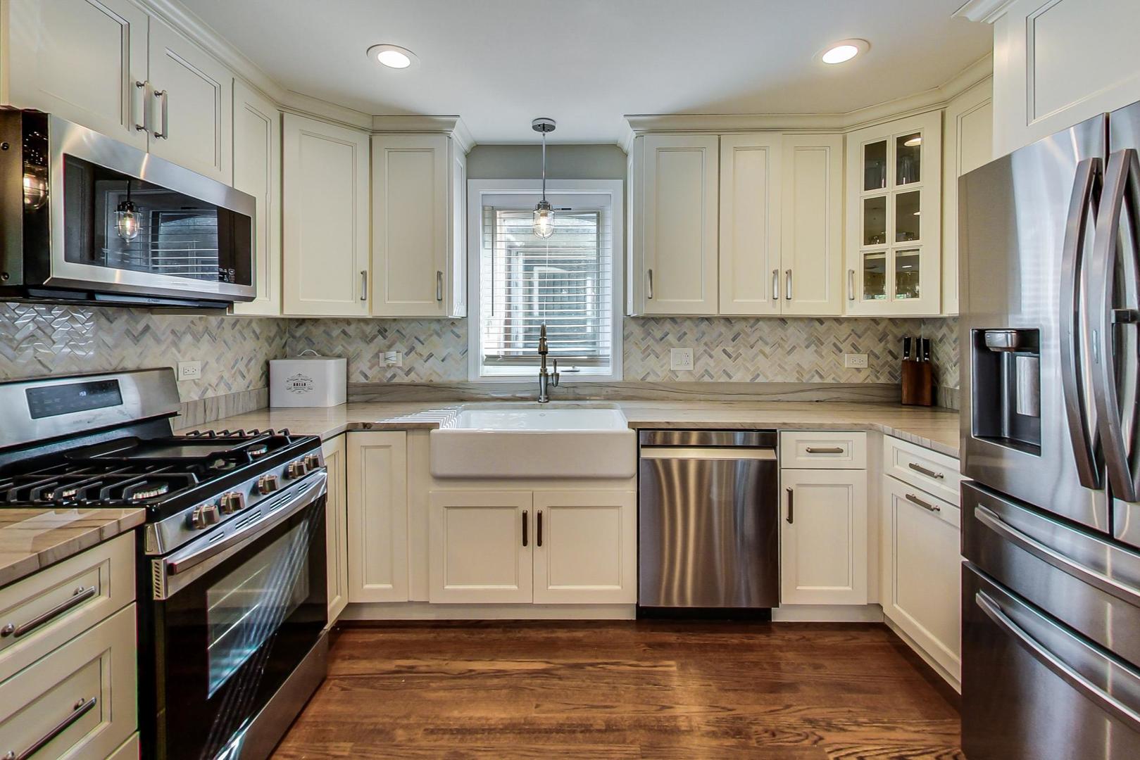 3702 South Normal Avenue Chicago, IL 60609 - Photo 8 of 36 a kitchen with stainless steel appliances a stove a sink and a microwave