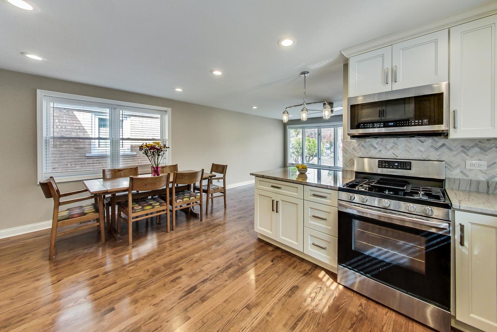 3702 South Normal Avenue Chicago, IL 60609 - Photo 10 of 36 a kitchen with stainless steel appliances a stove a sink a microwave a dining table and chairs