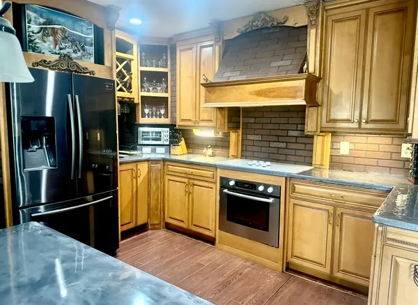 a kitchen with stainless steel appliances wooden floor dining table and chairs