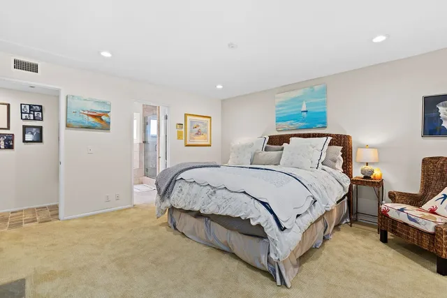 a spacious bedroom with a bed and painting on the wall