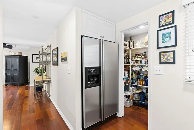 a view of a kitchen with refrigerator and wooden floor
