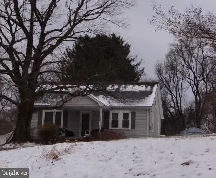 a front view of house with yard covered in snow