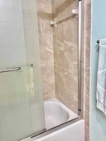 a bathroom with a granite countertop toilet sink and mirror