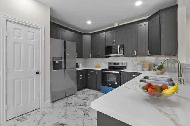 a kitchen with stainless steel appliances granite countertop a refrigerator sink and stove